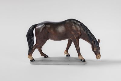 Cavallo marrone in ceramica policroma su base ovale