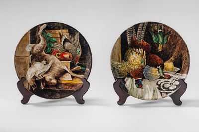 Manifattura Carbet, Coppia di piatti da parata in maiolica policroma con scene di cacciagione
