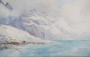 Paesaggio montano innevato con lago alpino