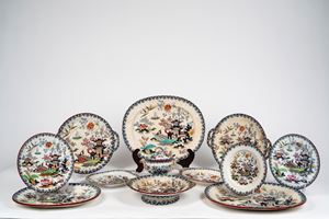 Manifattura Wedgwood, 1900 circa. Servizio di piatti in ceramica a decoro "chusan" policromo a paesaggi di gusto orientale, rami fioriti, uccelli e bordo con ghirlanda decorativa