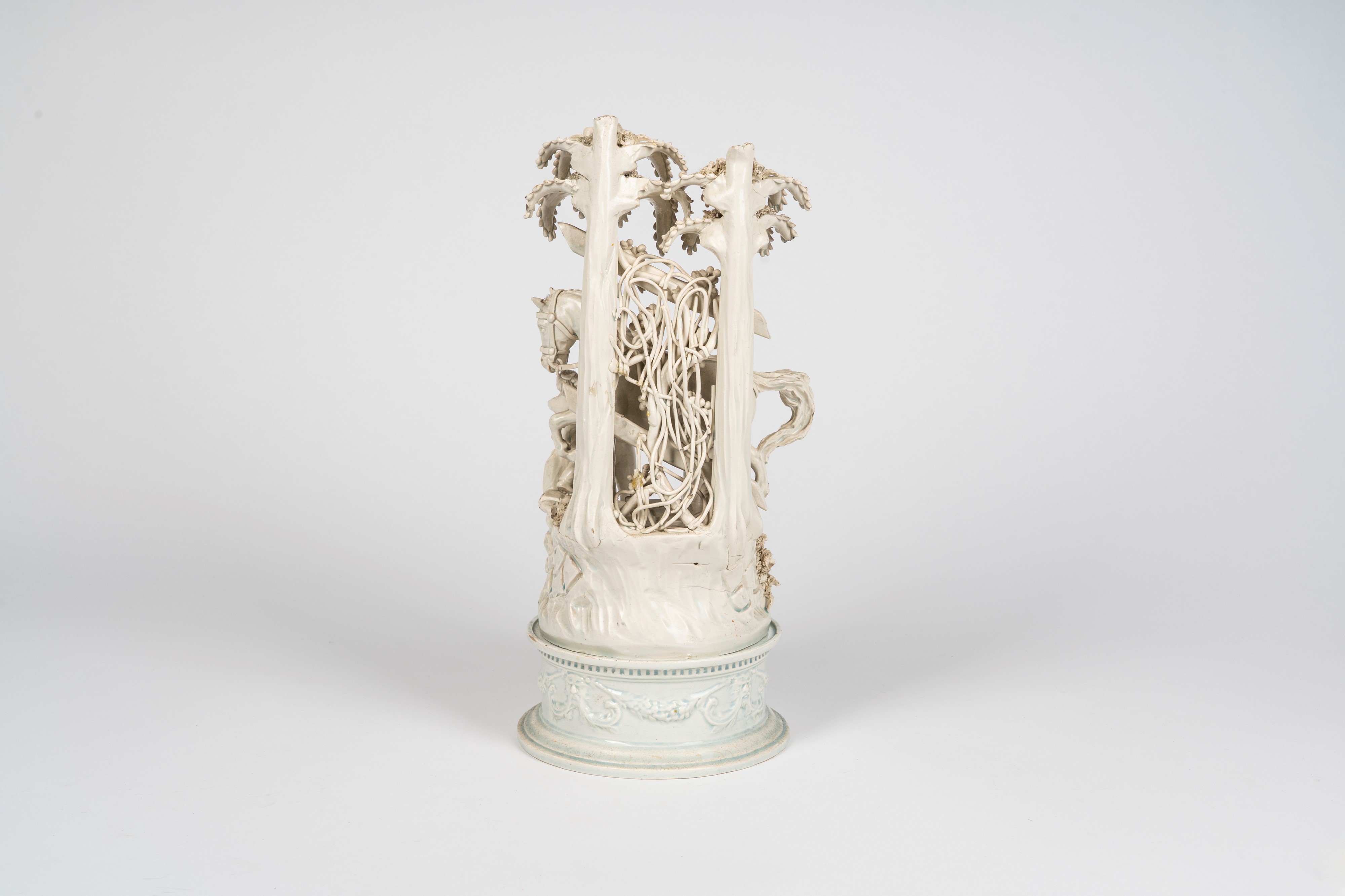 Gruppo in terraglia smaltata bianca raffigurante scena galante in un giardino con cavallo e giova...