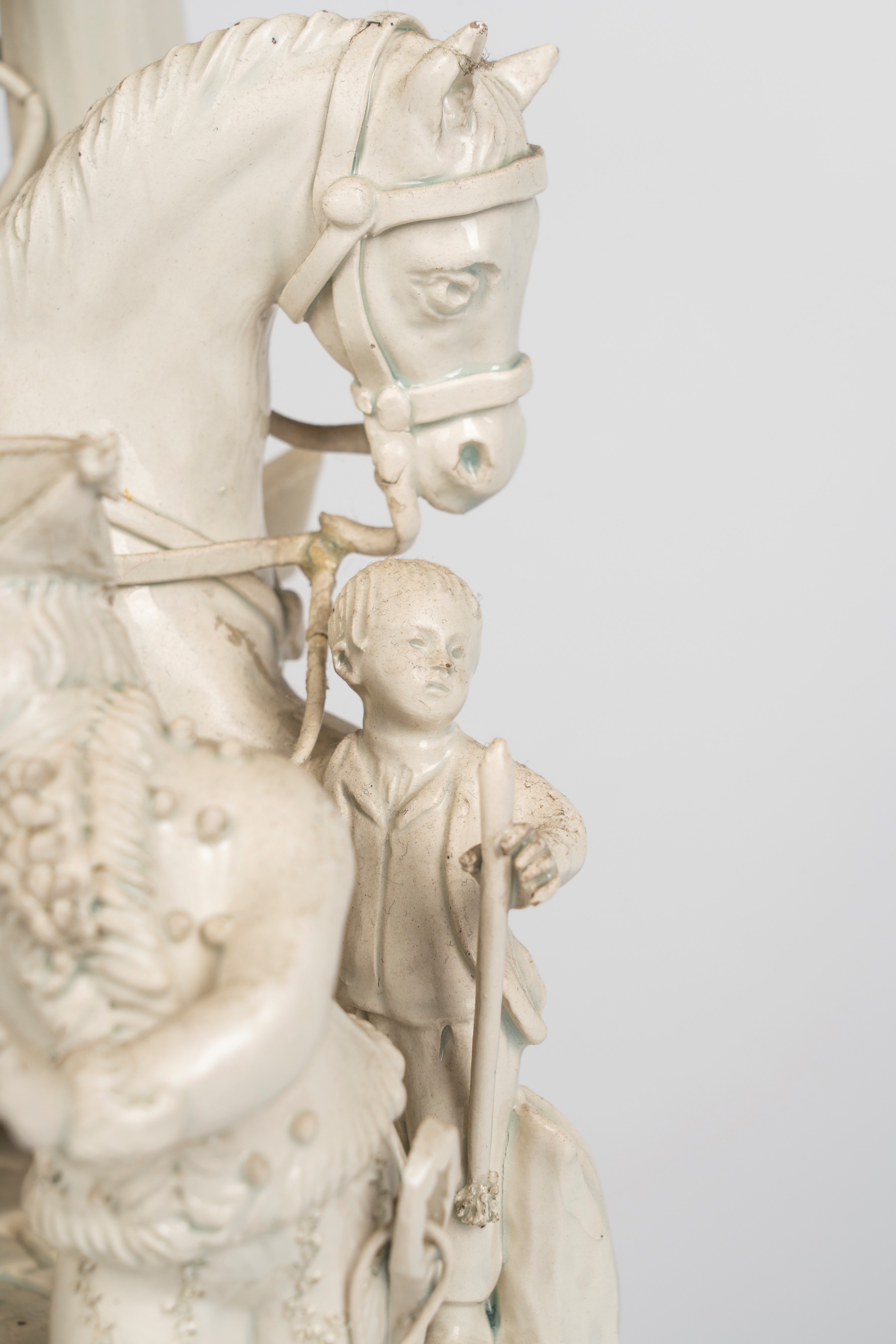 Gruppo in terraglia smaltata bianca raffigurante scena galante in un giardino con cavallo e giova...