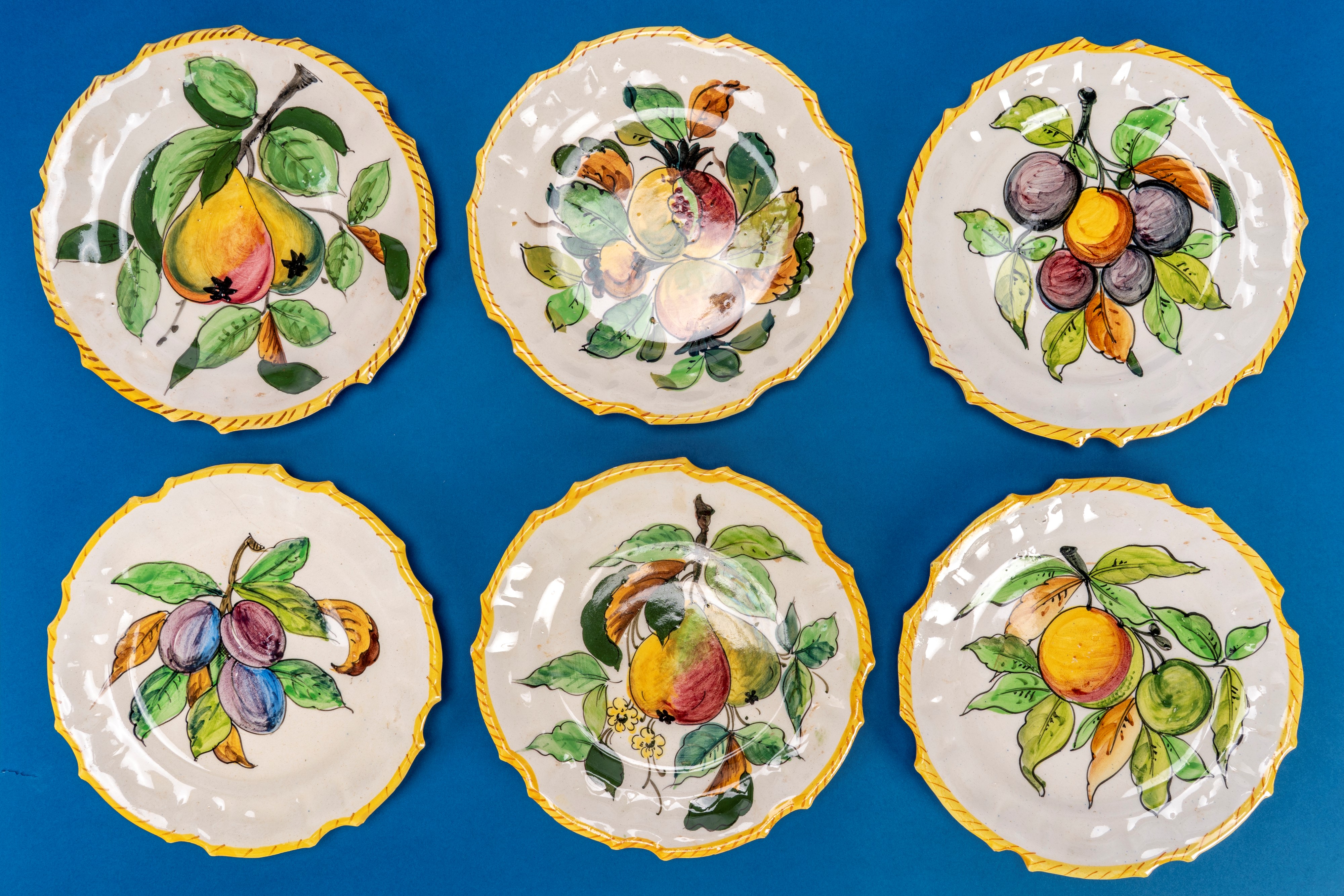 Piattini in ceramica smaltata policroma, decorazione a frutti, bordo mosso (set con saliera e pep...