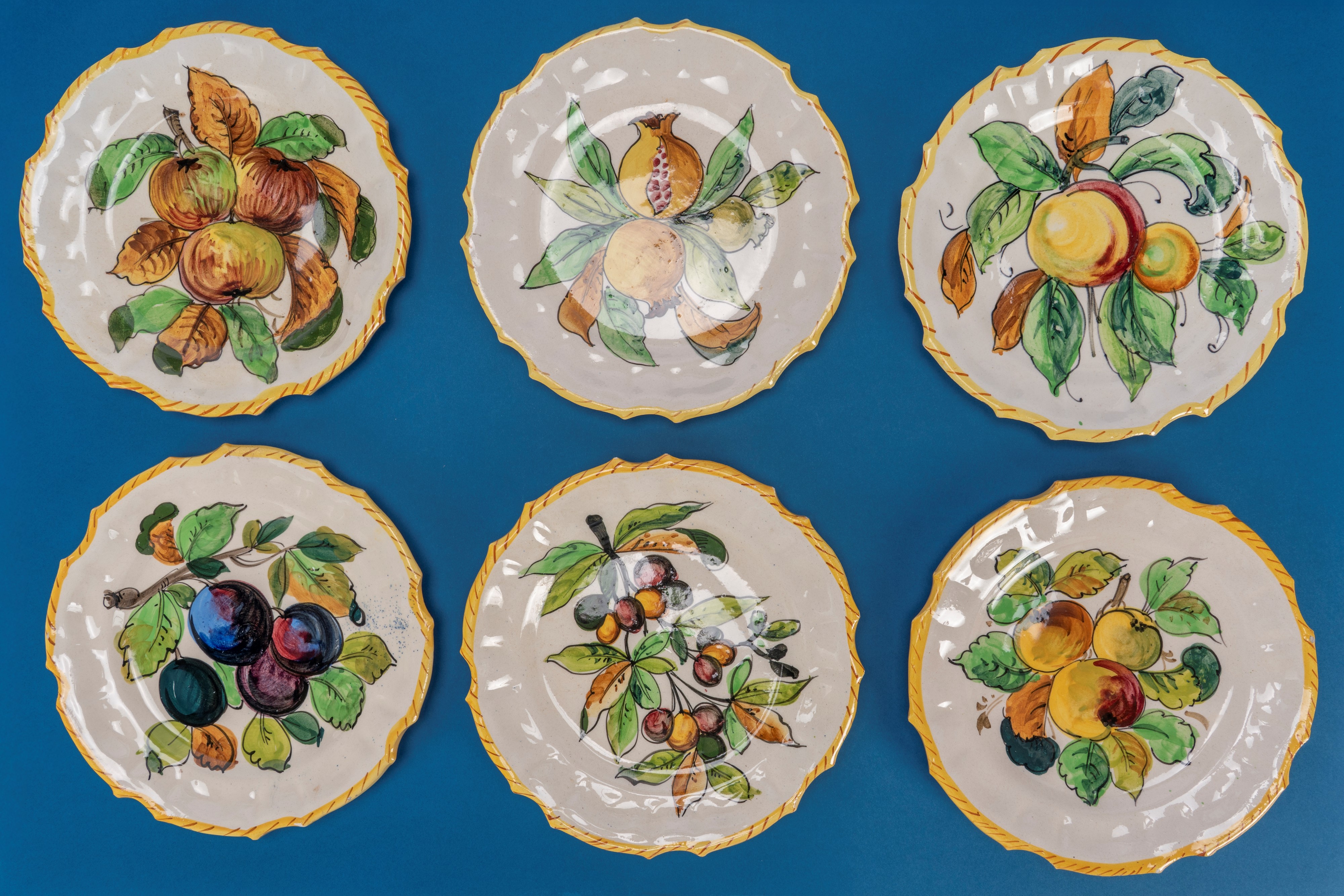 Piattini in ceramica smaltata policroma, decorazione a frutti, bordo mosso (set con saliera e pep...