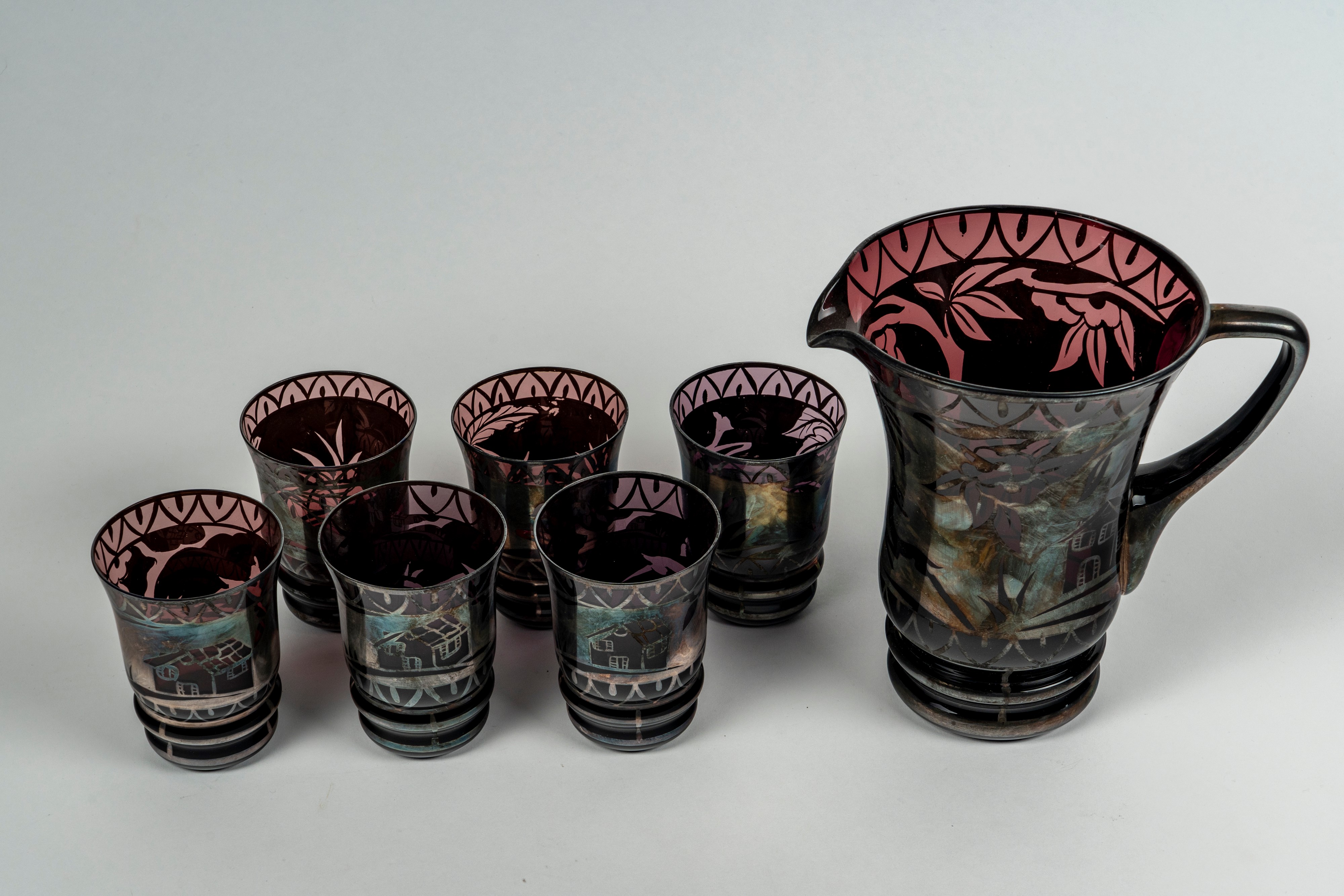 Una brocca e sei bicchieri in vetro color ametista e argentato