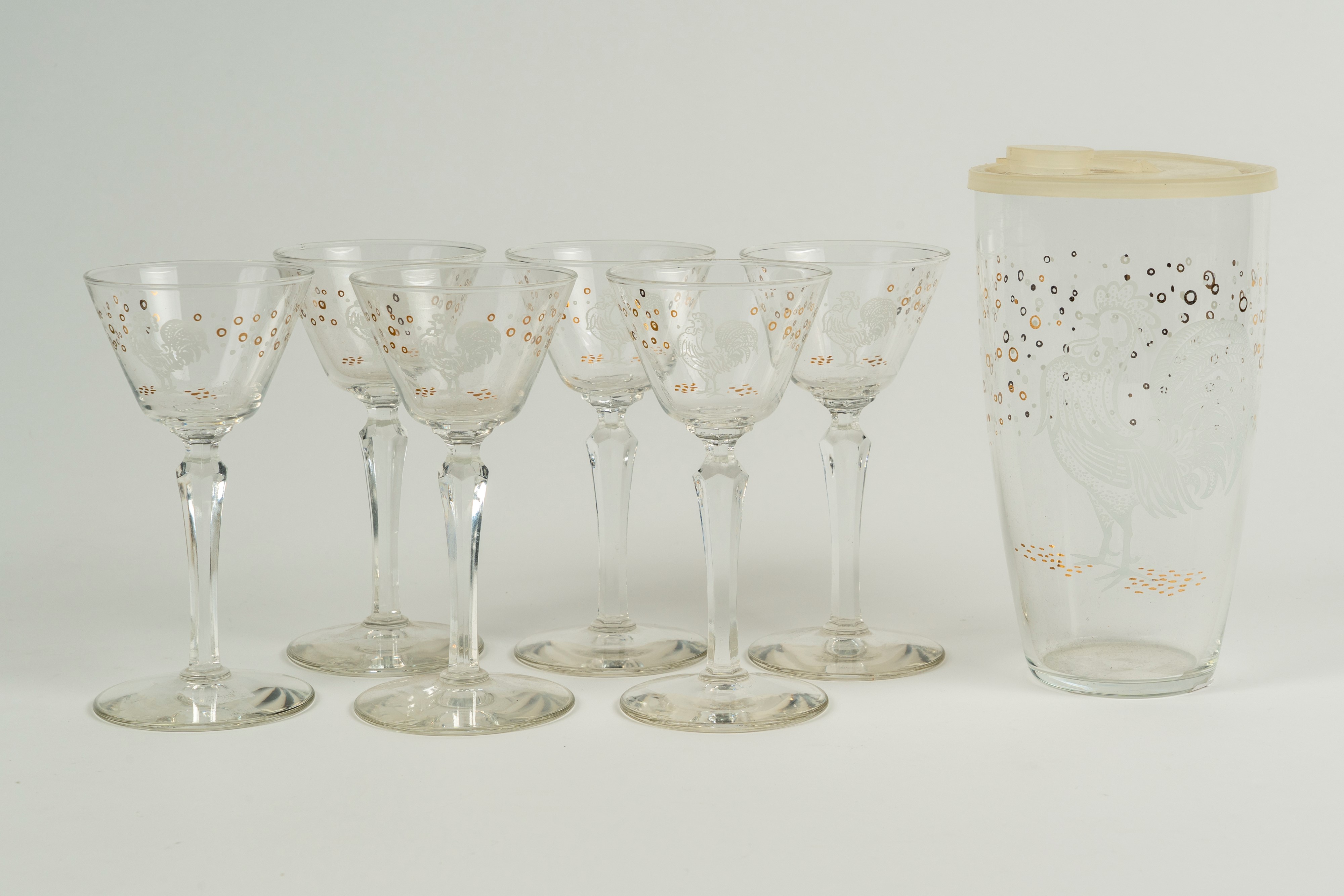 Set da rosolio composto da sei bicchieri, una brocca e un contenitore con tappo in vetro traspare...