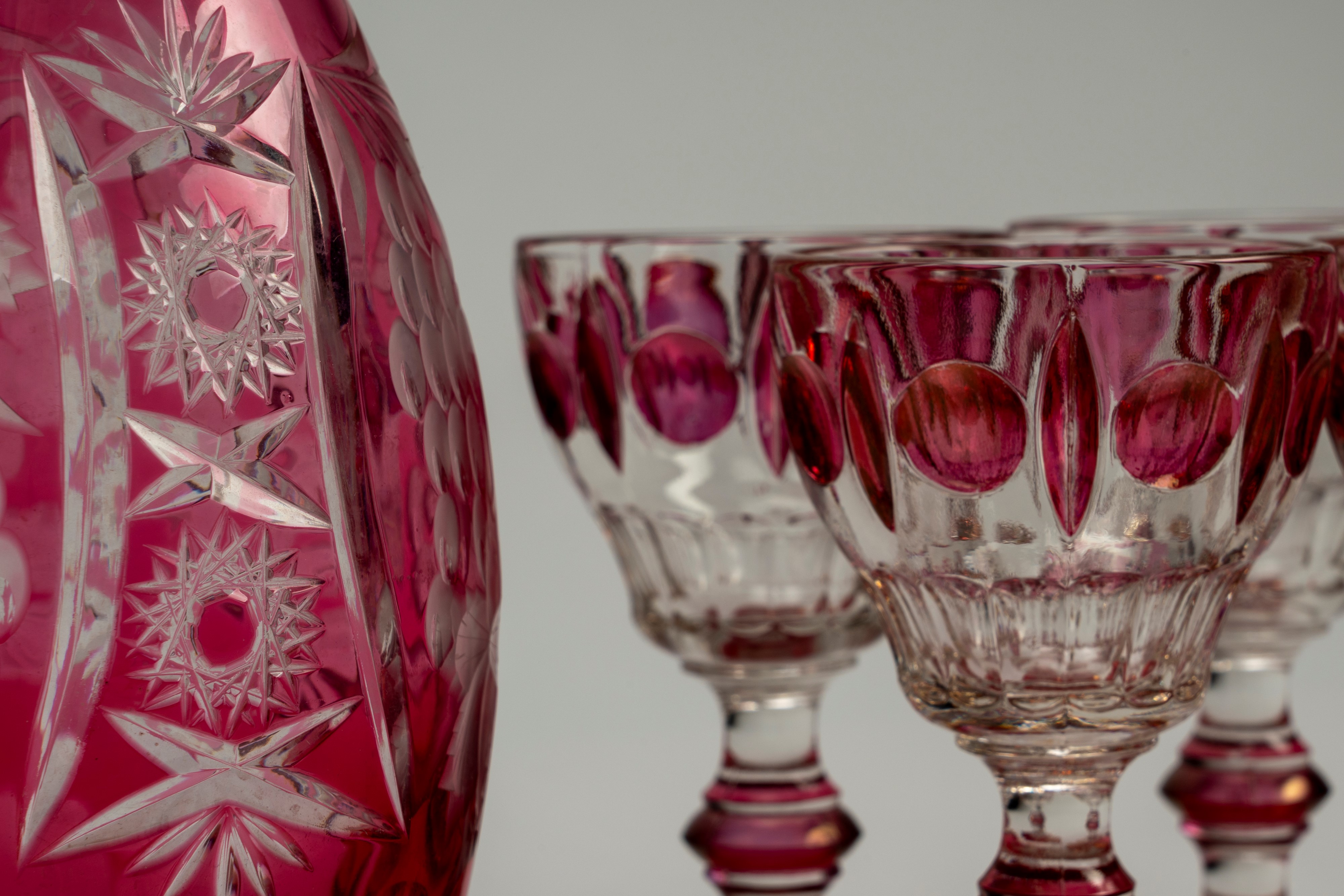 Lotto composto da una brocca in vetro color rubino inciso a tralci d'uva e motivi a stella e quat...