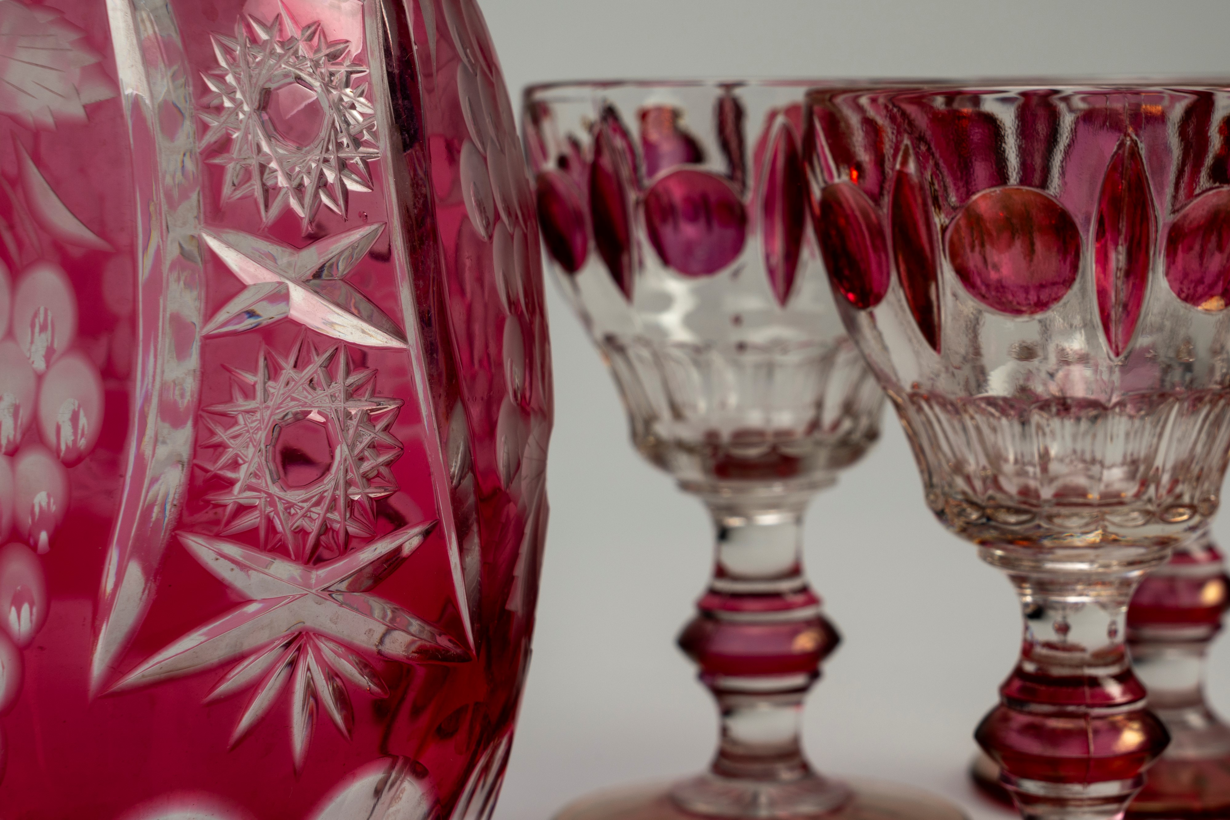 Lotto composto da una brocca in vetro color rubino inciso a tralci d'uva e motivi a stella e quat...