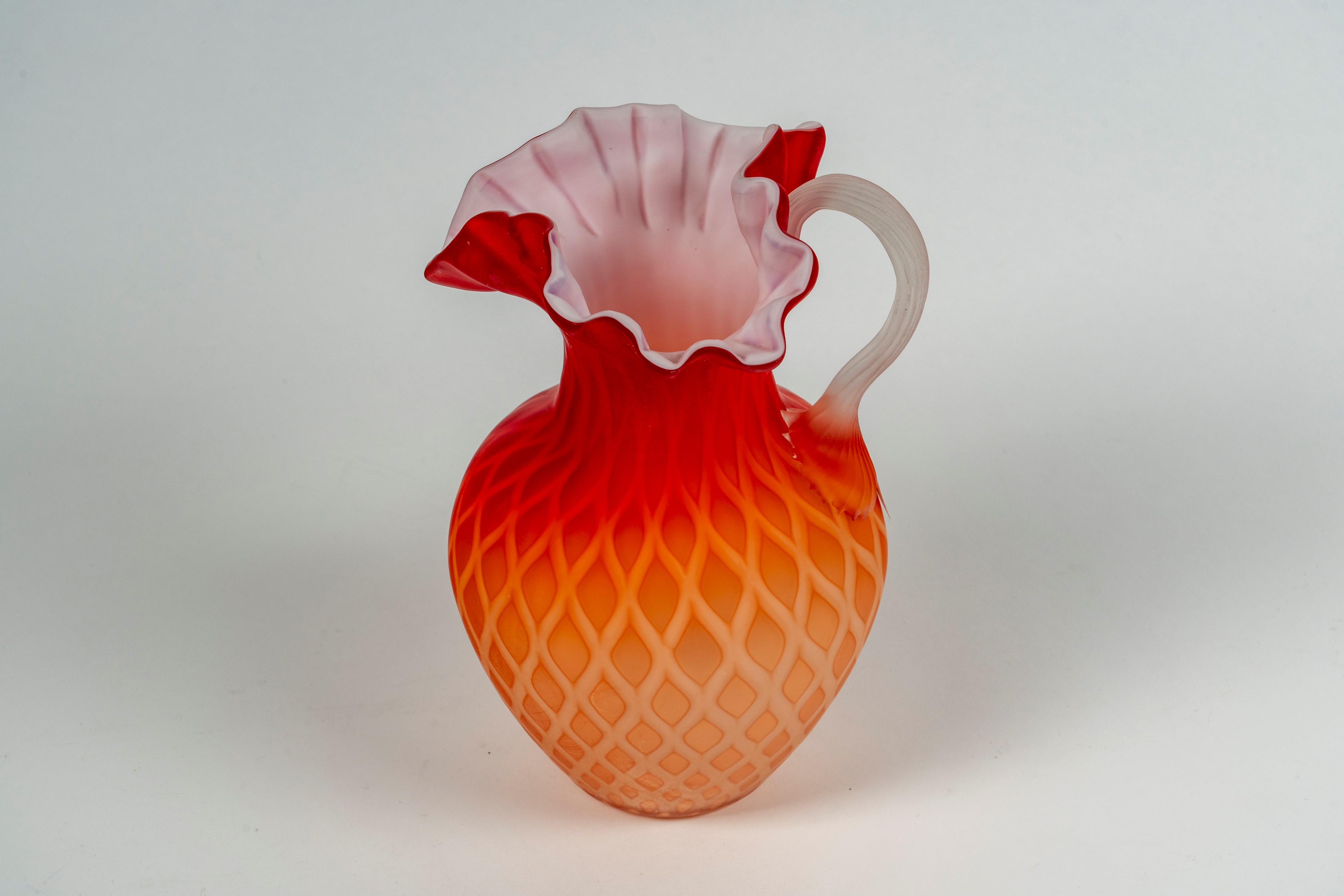 Brocca in vetro soffiato con ansa costolata applicata, bocca trilobata a profilo mosso con decoro...