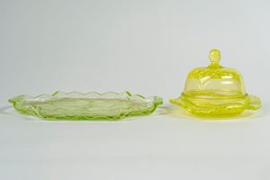 Lotto composto da un vassoio biansato di forma mossa e una burriera con coperchio in vetro verde uranio