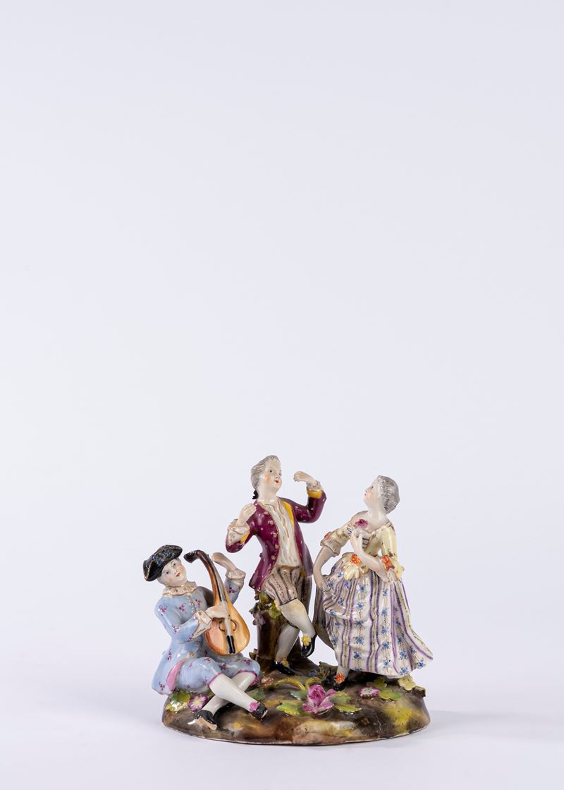 Gruppo in porcellana policroma raffigurante scena galante con suonatore di chitarra su zolla erbo...