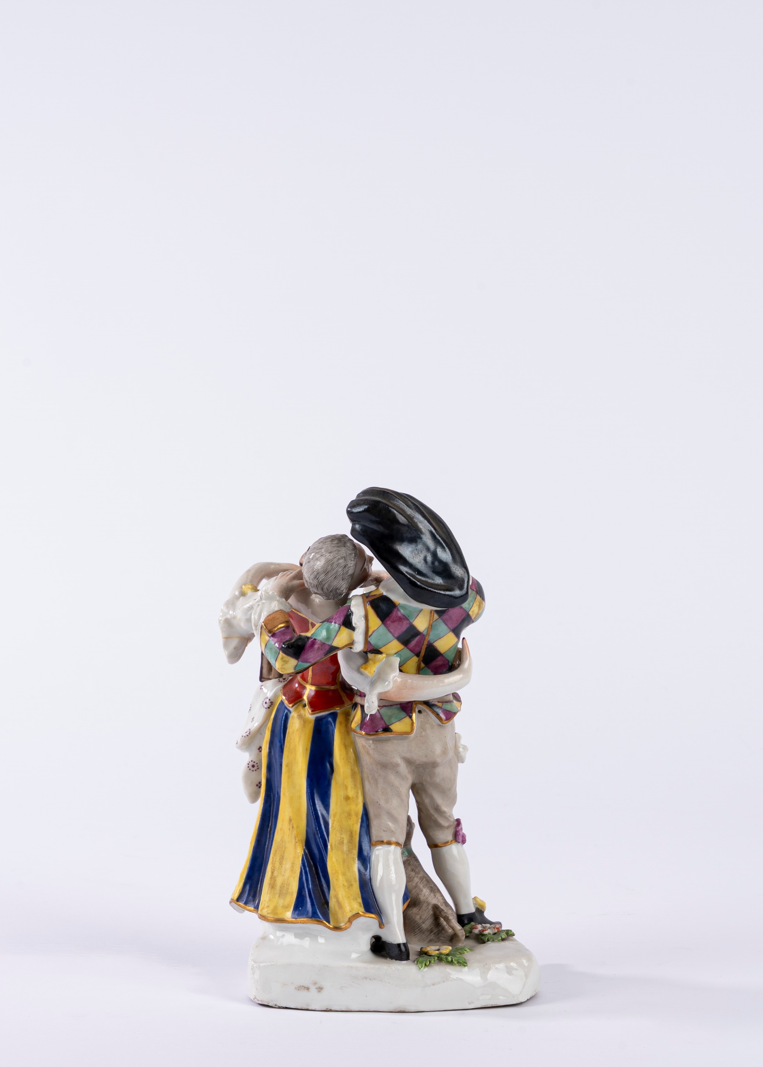 Gruppo in porcellana policroma raffigurante Scaramuccia e Colombina su una base a zolla con cagno...