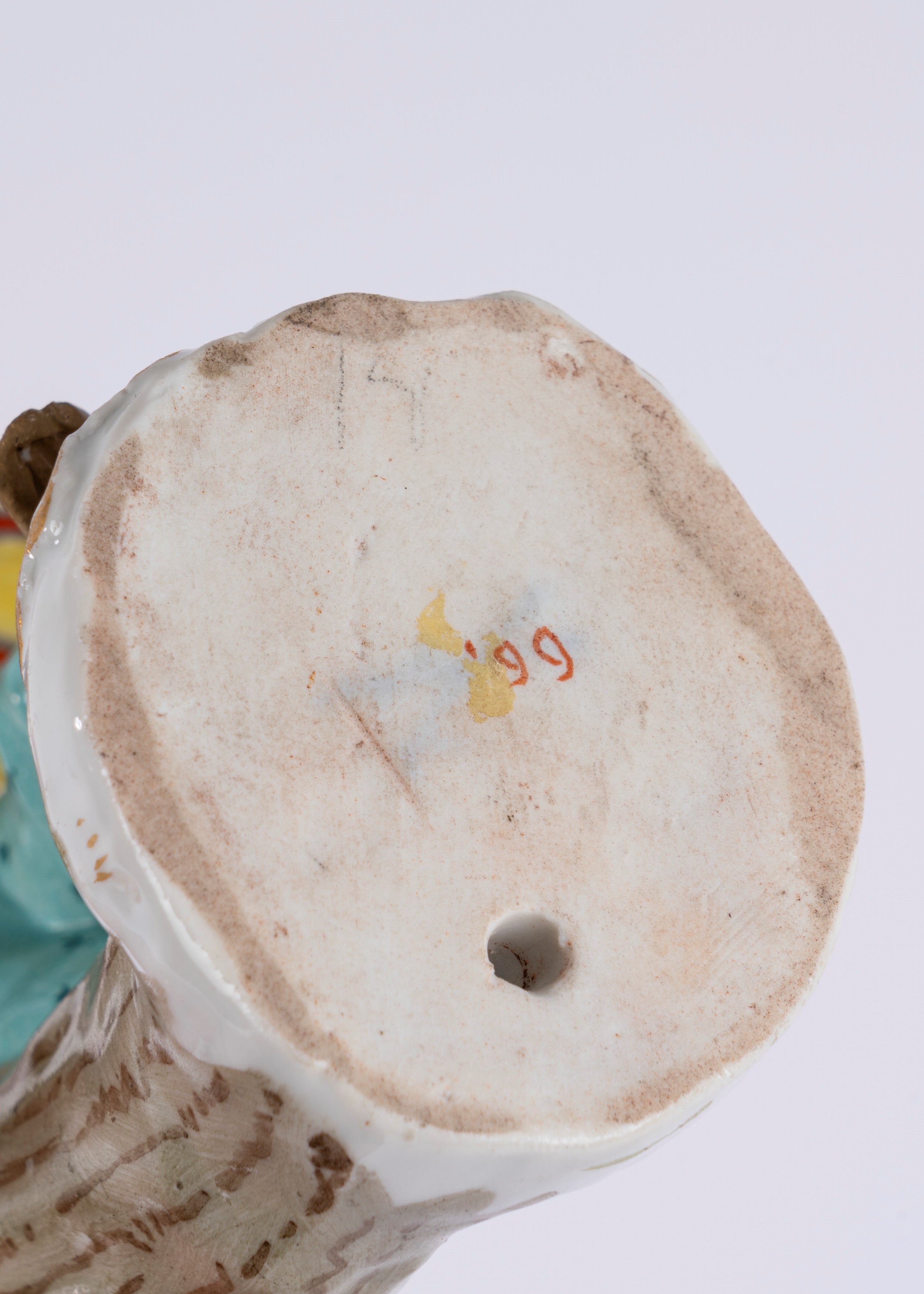 Figura in porcellana policroma raffigurante scimmietta musicante con tamburo, su base a rocaille....