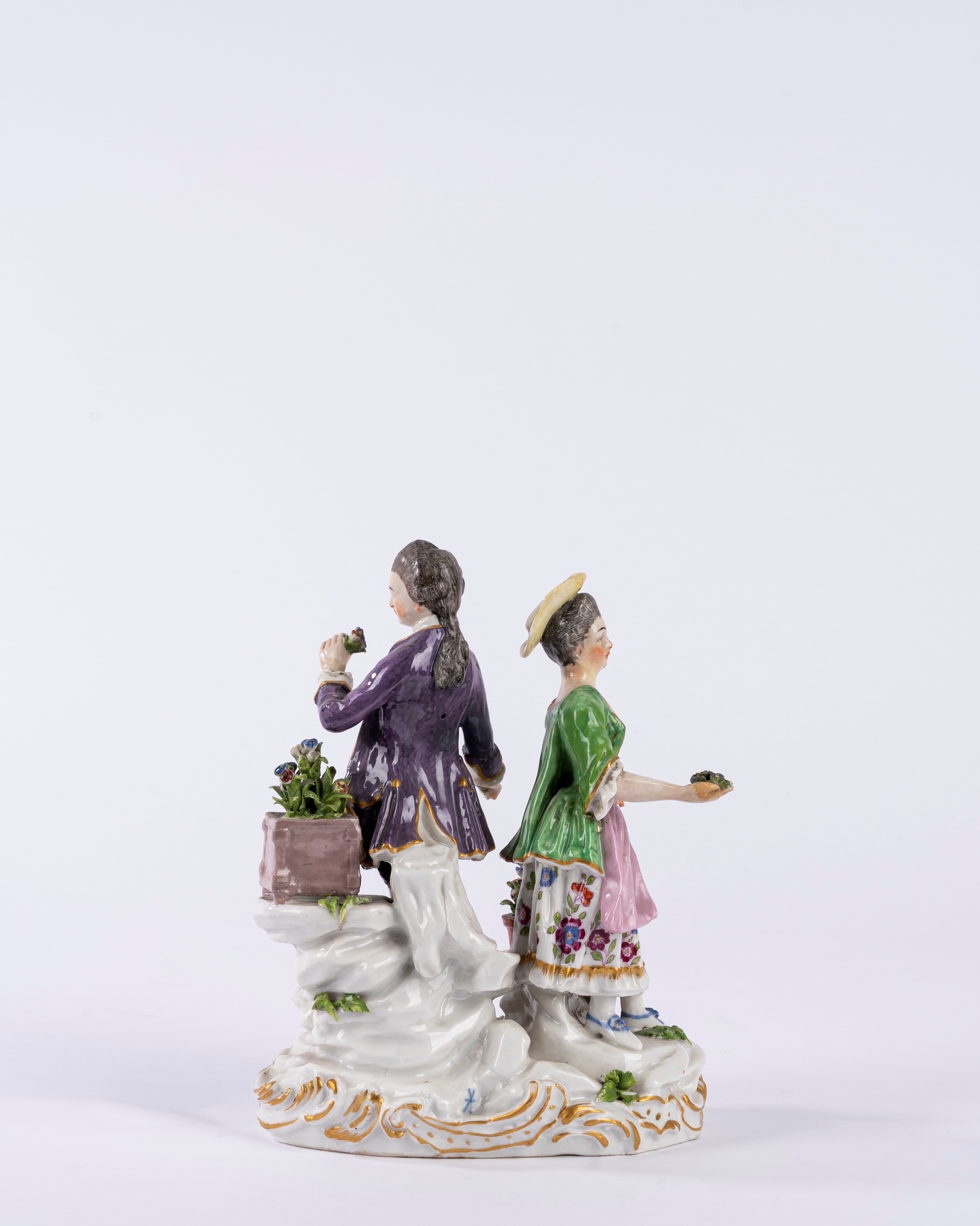 Gruppo in porcellana policroma raffigurante due figure in un giardino, su base a rocaille. Manifa...