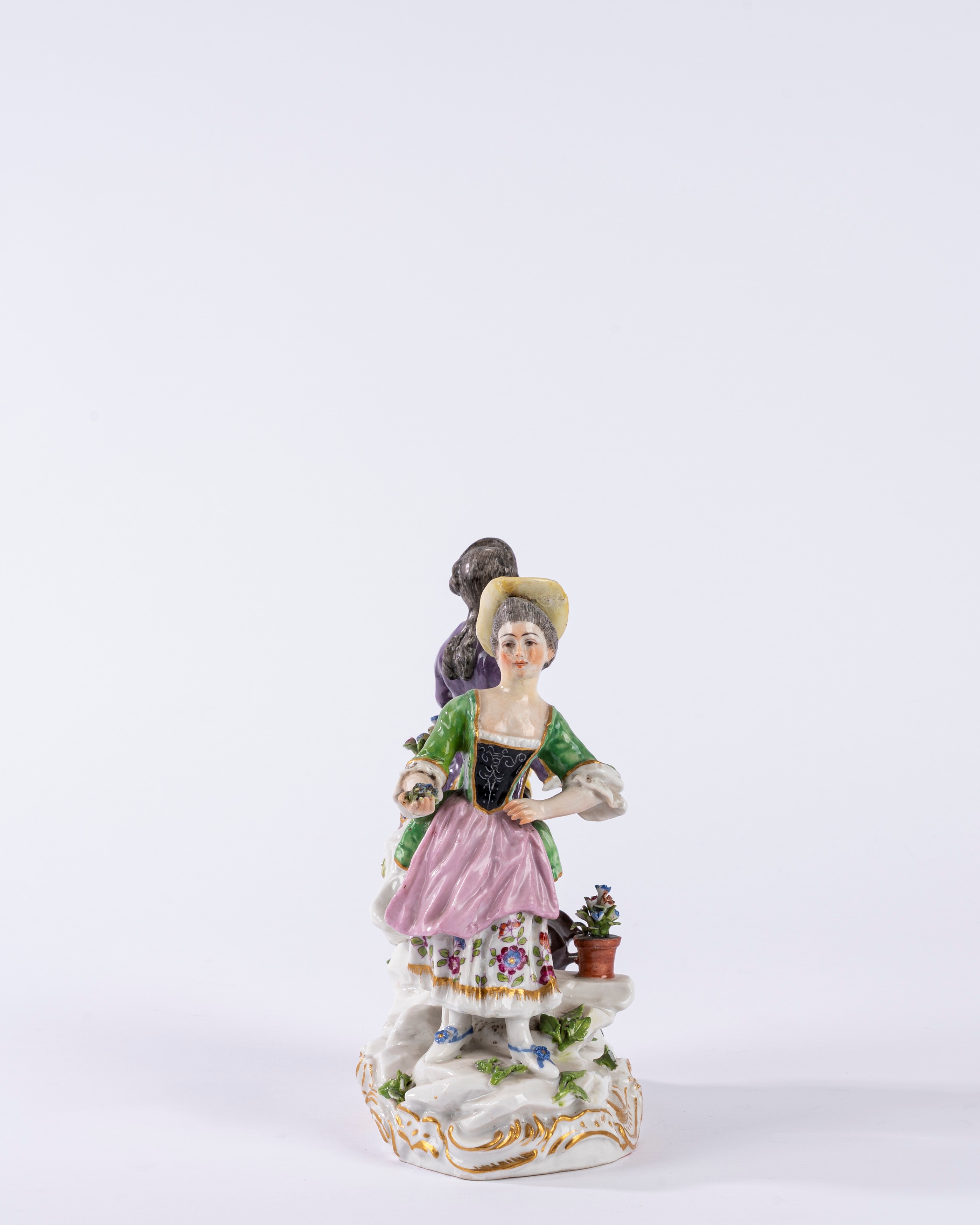 Gruppo in porcellana policroma raffigurante due figure in un giardino, su base a rocaille. Manifa...