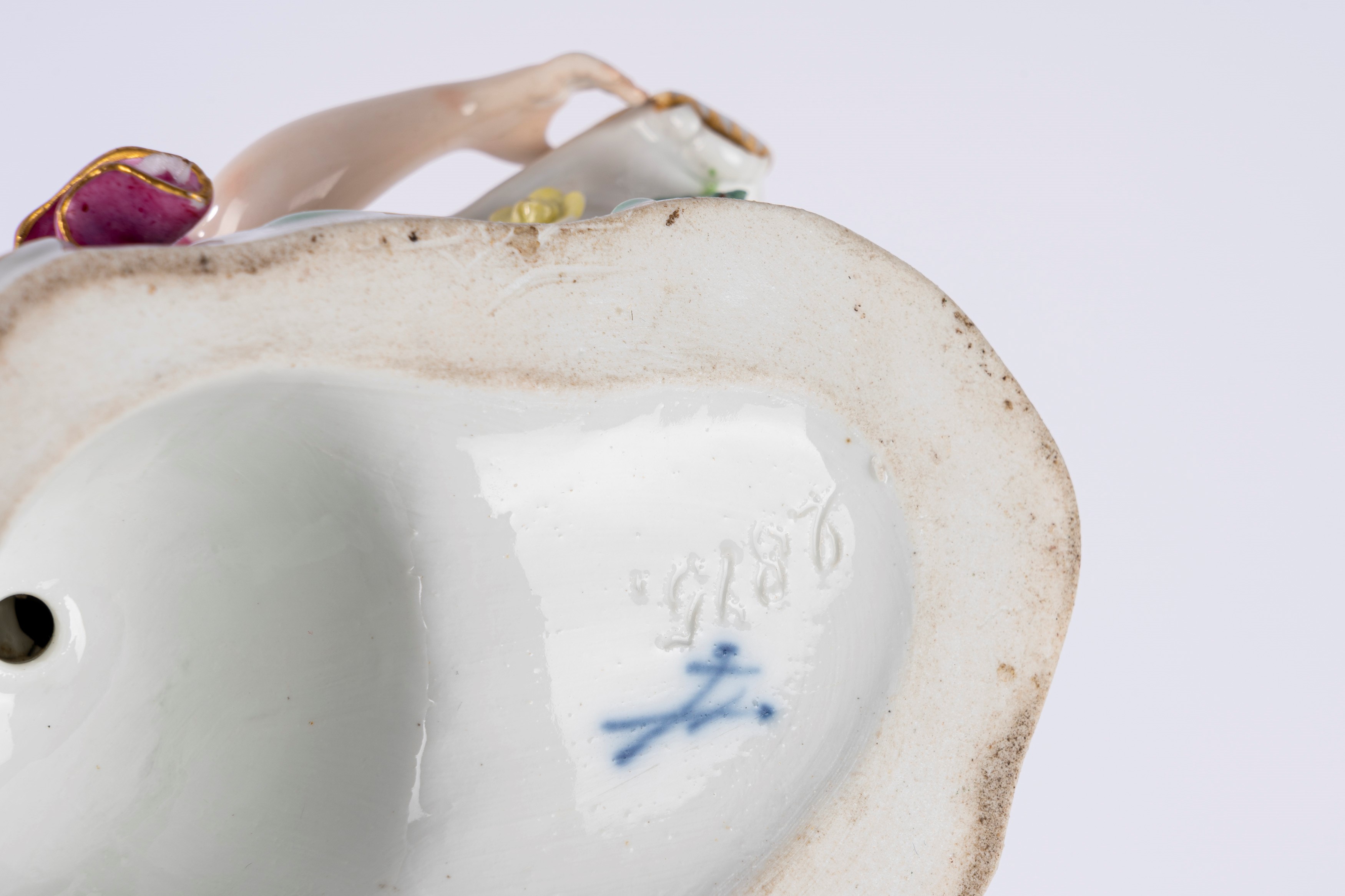 Coppia di saliere o salsiere in porcellana policroma in forma di fanciulla sdraiata che sostiene ...