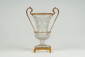 Two-handled vase in cut crystal mounted in gilded bronze on a square base resting on four scrolled feet. Late 19th-early 20th century.