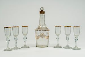 Set da liquore composto da una bottiglia e sei calici in vetro con decori e bordo in oro. Fine secolo XIX-inizo XX