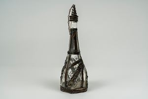 Bottiglia con tappo in vetro incolore a base esagonale montata in metallo argentato lavorato a filigrana. Probabilmente Turchia, secolo XIX