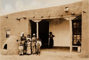 Ad Agua Fria, una famiglia in posa davanti a una casa in mattoni di fango, New Mexico