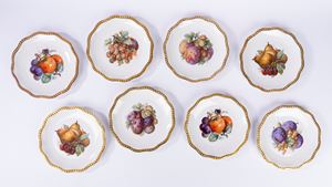 Otto piatti da frutta in porcellana con decoro policromo alla frutta e bordo mosso dorato. Bavaria, Roloff, secolo XX