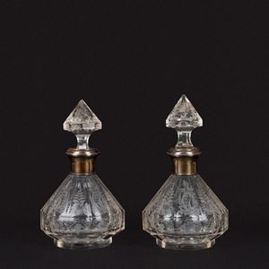 Coppia di decanter in cristallo inciso a motivi vegetali e una bottiglia con tappo in cristallo ornata da decorazioni in bronzo dorato (h cm 24) 