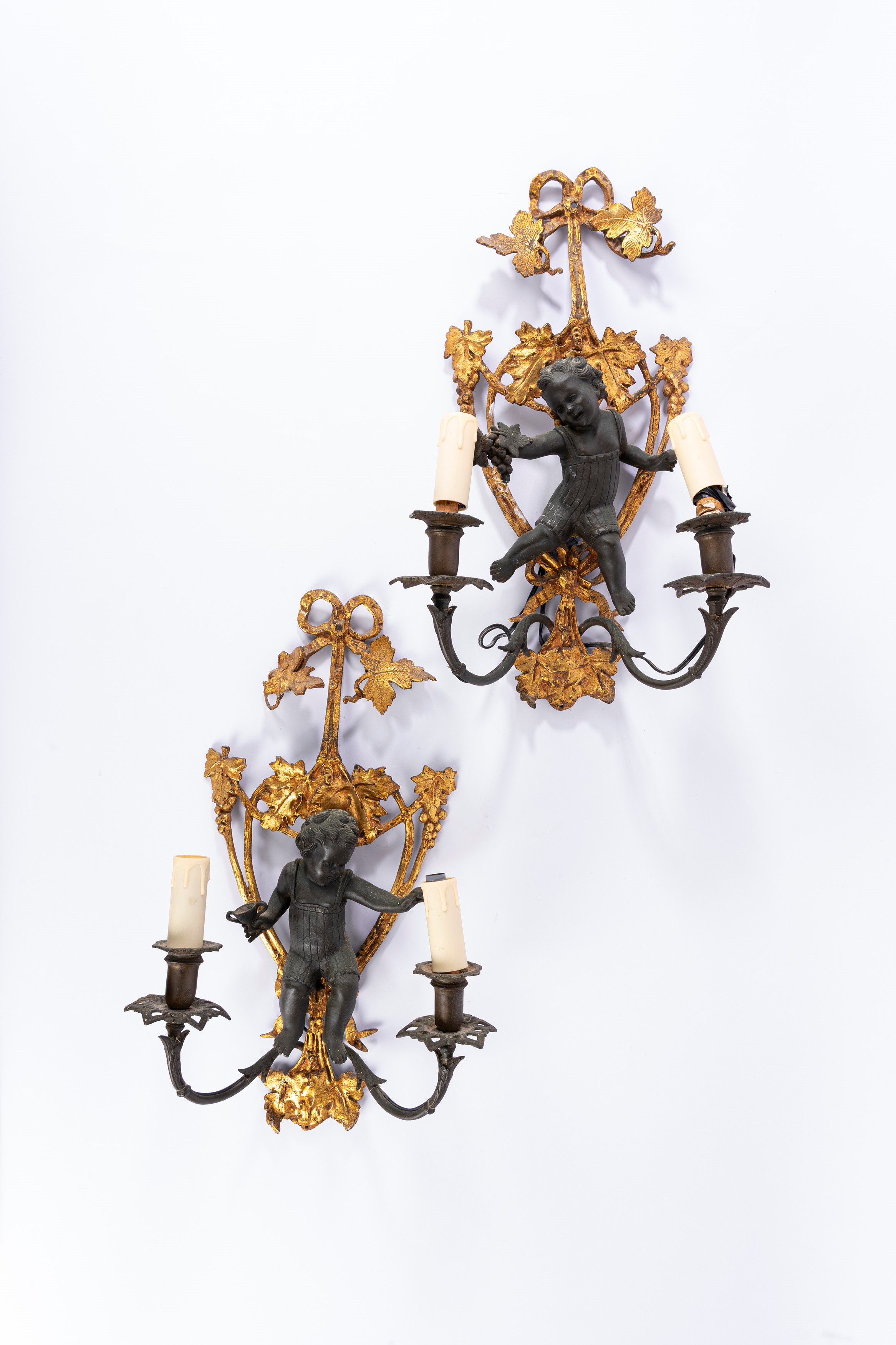 Coppia di appliques a due luci, bronzo dorato e patinato con putto a rilievo, XIX secolo
