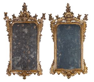 A pair of carved and gilded wooden mirrors with frames decorated with leaf and flower scrolls. 18th century.
