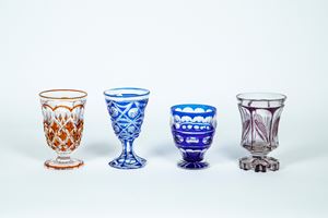 Lotto di quattro bicchieri in cristallo molato trasparente e policromo nei toni del blu, viola e arancio
