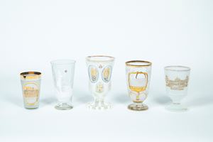 Cinque bicchieri in vetro e cristallo trasparente e bianco decorato a dorature con soggetti differenti