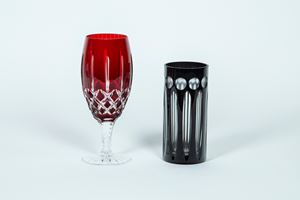 A tall glass and a drink glass in clear and red black crystal
