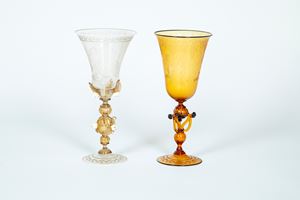 Due calici da parata in vetro soffiato di Murano uno trasparente e l'altro color ambra incisi a bulino uno con leone di san Marco e l'altro a putti bacchici, XX secolo