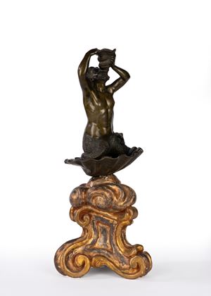 Patinated bronze triton on a carved and gilded wooden rocaille base. 18th century.