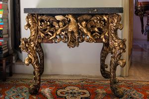 Console di forma mossa in legno riccamente intagliato e dorato a volute, fiori e frutti con piano in marmo. Sicilia, secolo XVIII