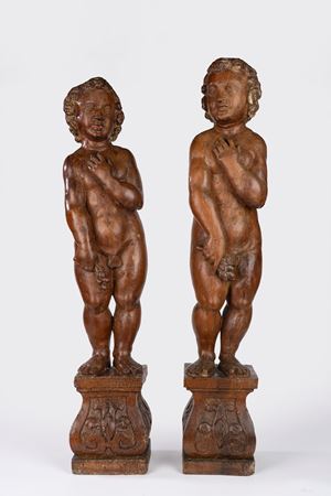 Coppia di putti in legno intagliato su basi a plinto. Fine secolo XVII