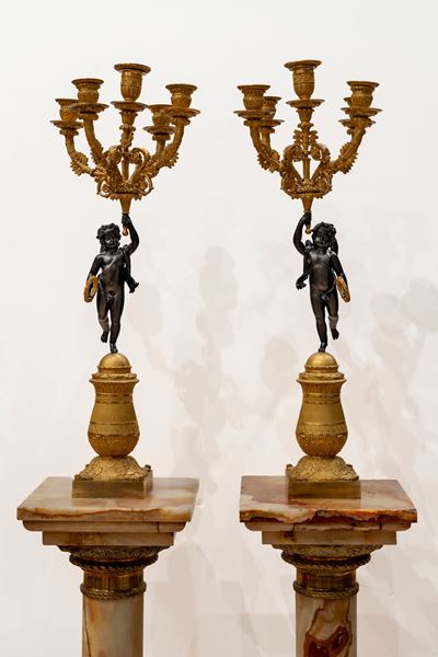 Coppia di candelabri a cinque luci in bronzo brunito e dorato, supportati da putto, Francia, prim...
