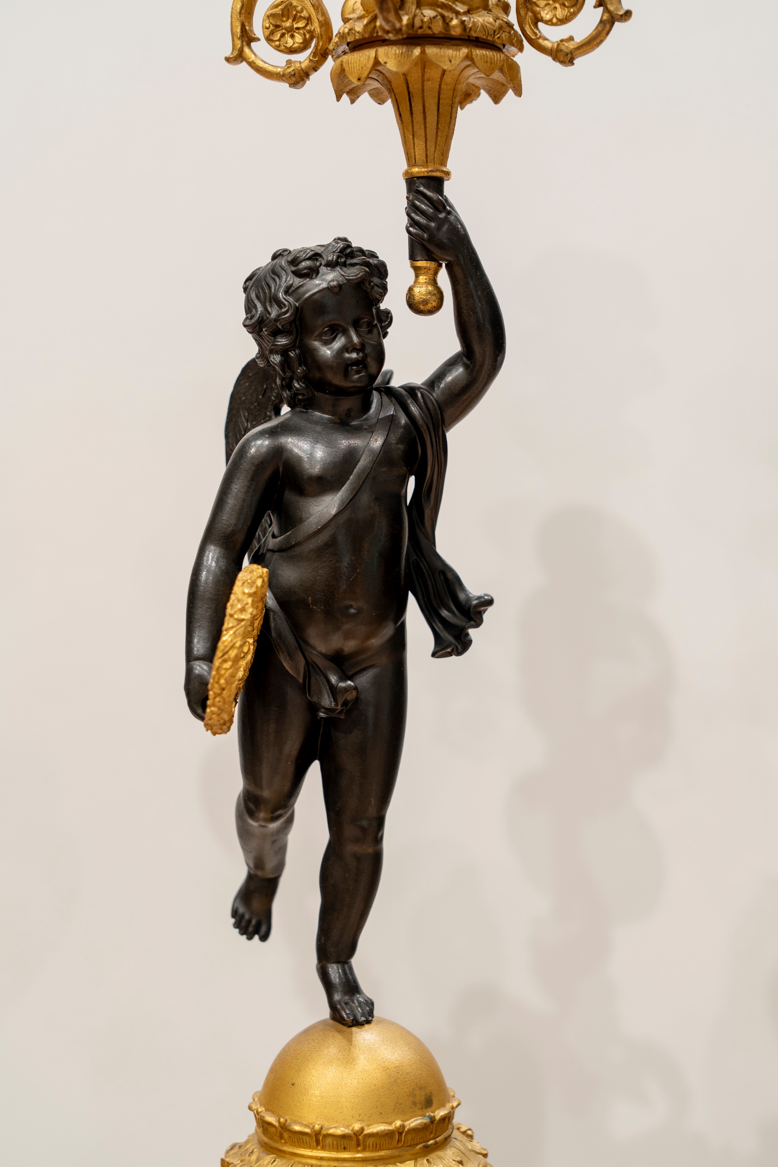 Coppia di candelabri a cinque luci in bronzo brunito e dorato, supportati da putto, Francia, prim...