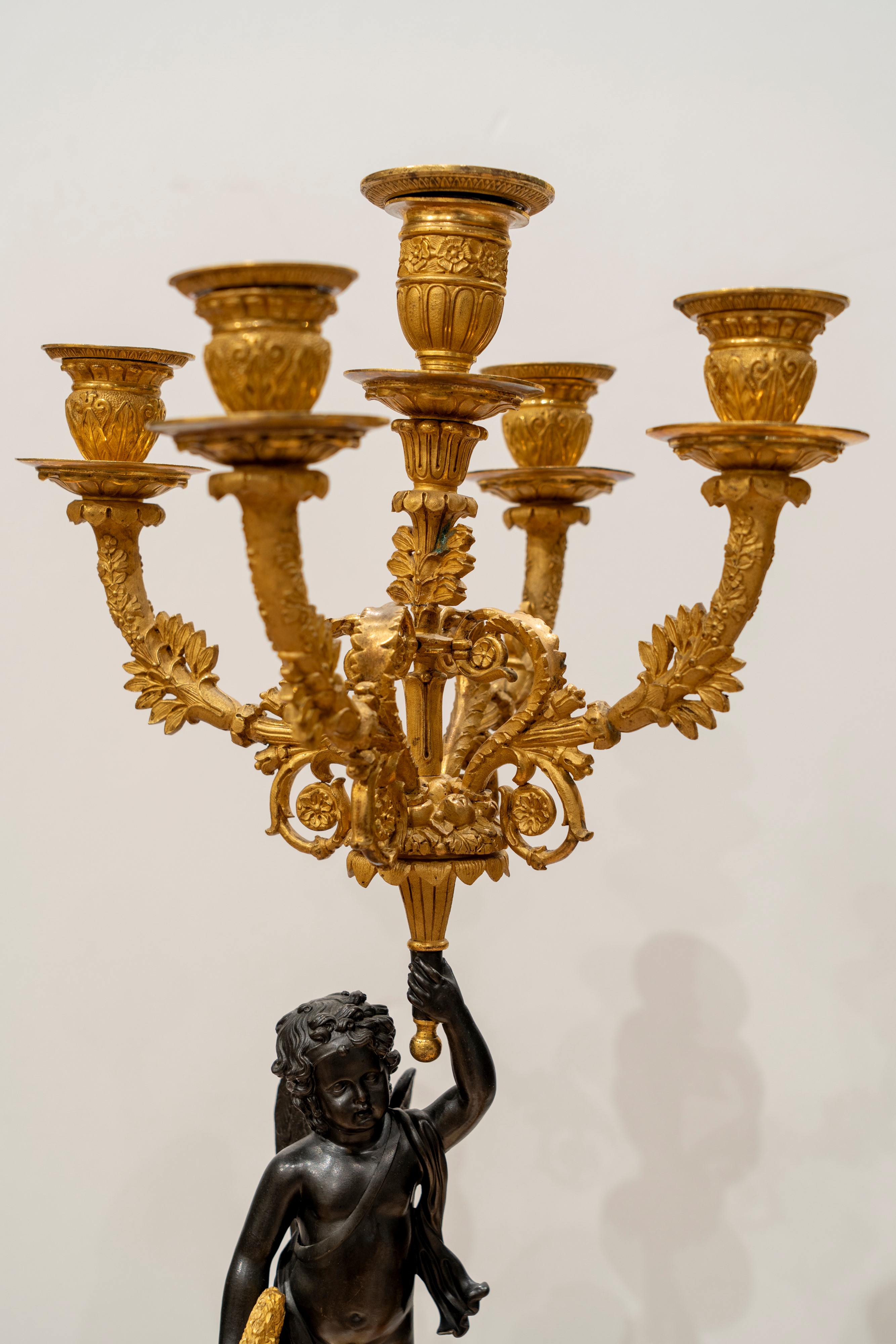 Coppia di candelabri a cinque luci in bronzo brunito e dorato, supportati da putto, Francia, prim...