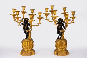 Coppia di candelabri a sei luci in bronzo dorato e patinato con fusto a fauno. Da un modello di Clodion, Francia, inizio secolo XX