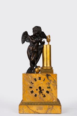 Orologio da appoggio in marmo giallo di Siena, bronzo dorato e patinato sormontato da Cupido. Francia, secolo XIX 
