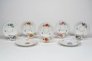 Cinque tazze con piattino e due piattini da dolce in porcellana decorata a fiori. Meissen, fine secolo XIX-XX