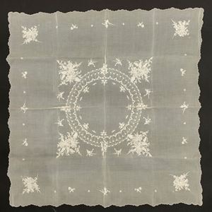 Wavy edge tablecloth with central oval medallion surrounded by a bouquet of flowers 