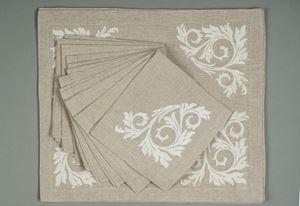 Eight linen placemats with twelve dove-grey napkins hand-embroidered with a white swirl decoration, Bertozzi