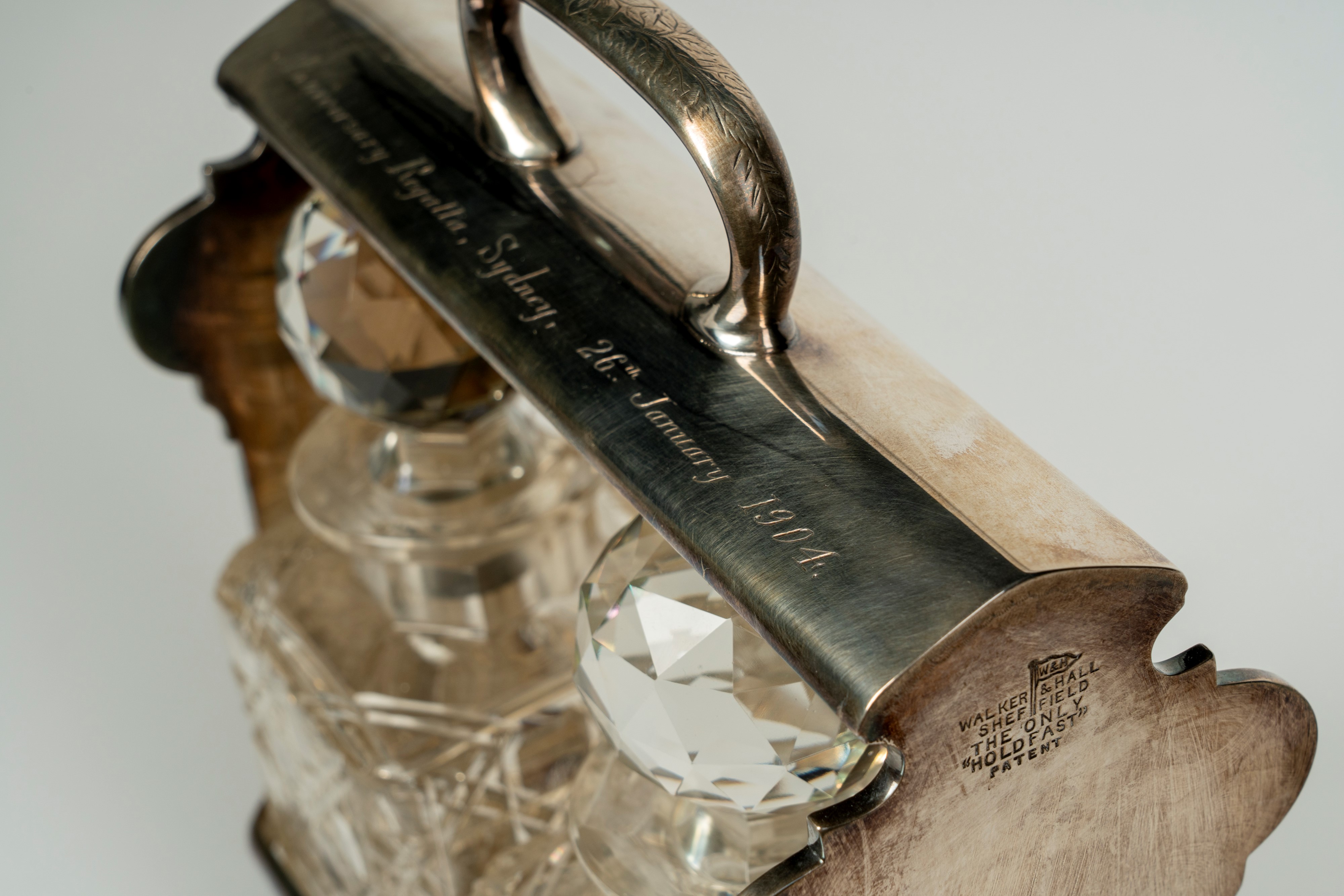 Tantalo in metallo dorato con due decater in cristallo sfaccettato, Walker & Hall Sheffield the o...