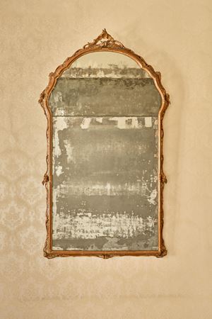 Specchiera di forma mossa con cornice in legno intagliato e laccato a motivi floreali, cimasa traforata e cuspidata. Venezia, secolo XVIII