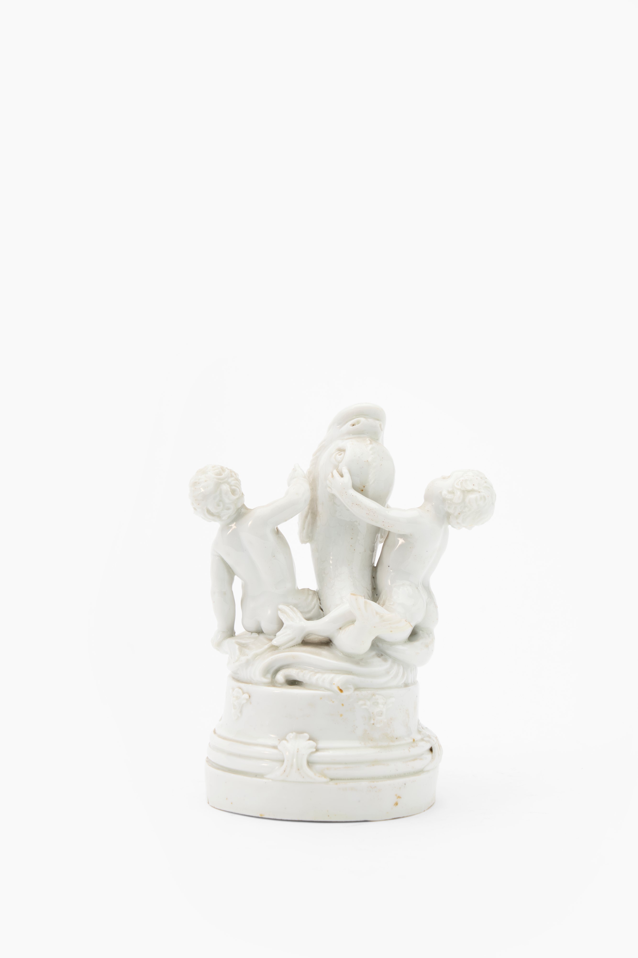Gruppo in porcellana bianca raffigurante due putti tritoni che giocano con un delfino. Nove di Ba...