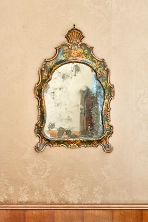 Specchiera di forma mossa in legno intagliato e laccato a volute e fiori. Venezia, secolo XVIII