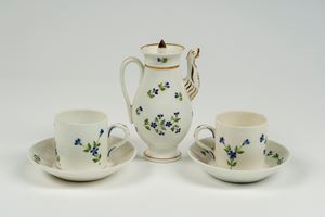 Due tazze con piattino e una caffettiera in porcellana bianca con decoro a fiordalisi, fine secolo XVIII