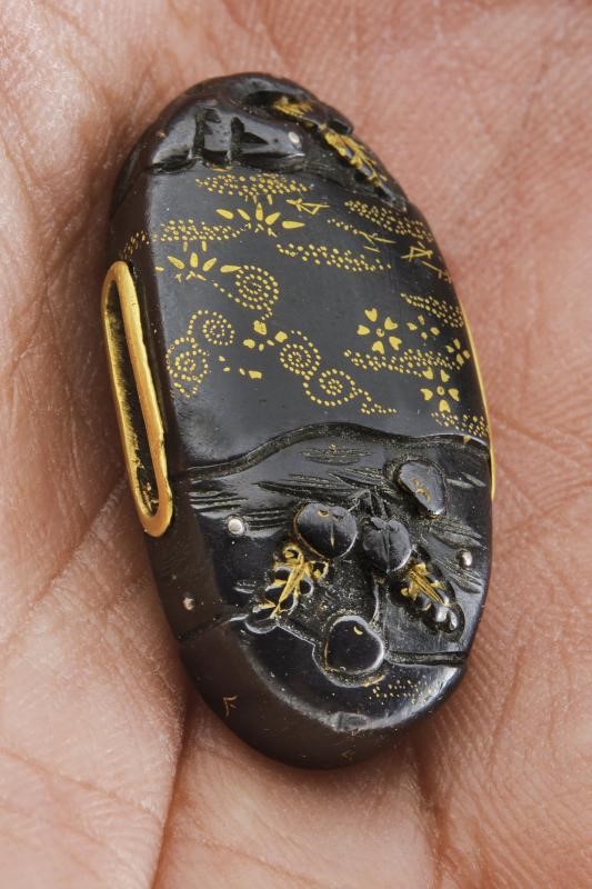 Giappone, Fuchi-kashira in shakudo nanako-ji con decoro in takabori e intarsi in oro