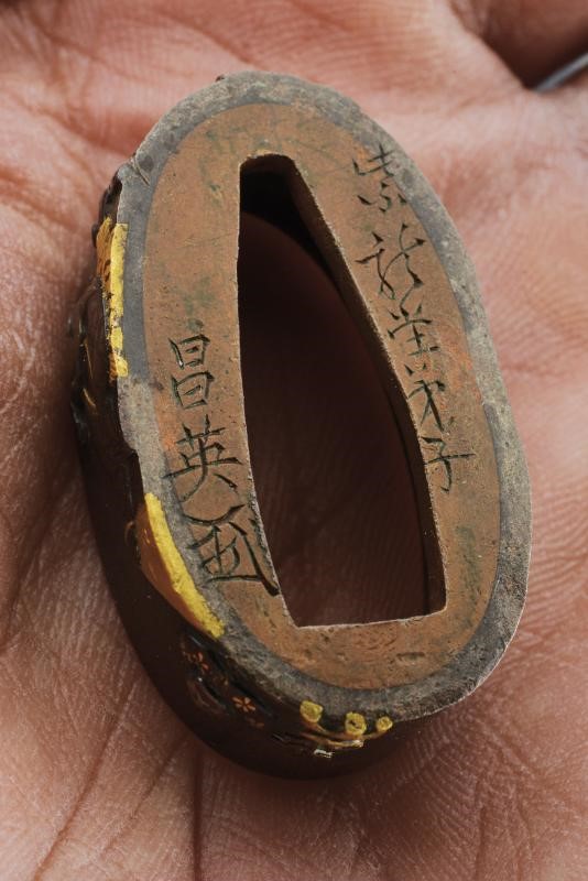 Periodo Edo, Fuchi-kashira in shakudō e oro con decorazioni a bassorilievo e inserto in argento